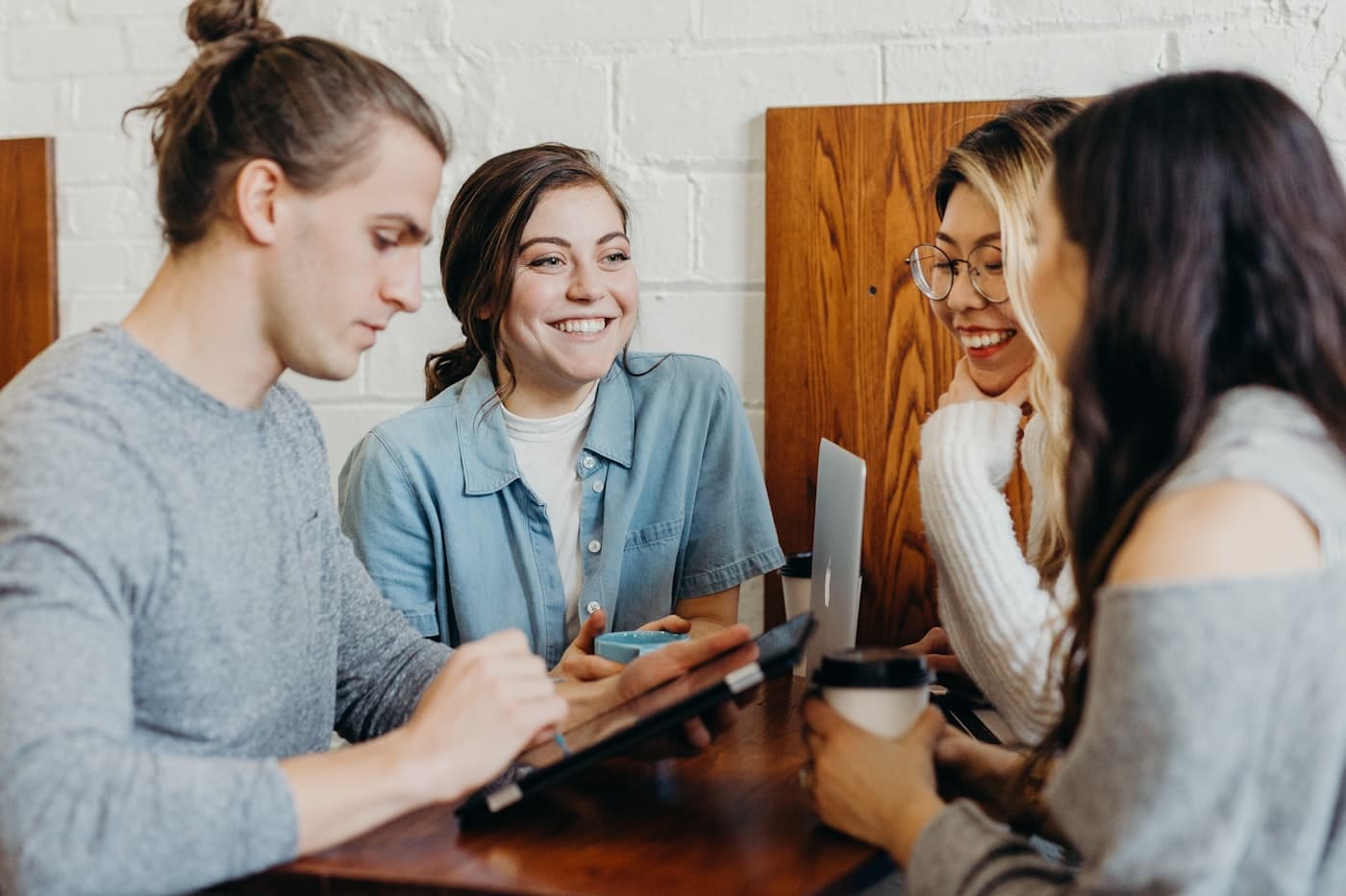 A smiling client sending a receipt from her phone over coffee